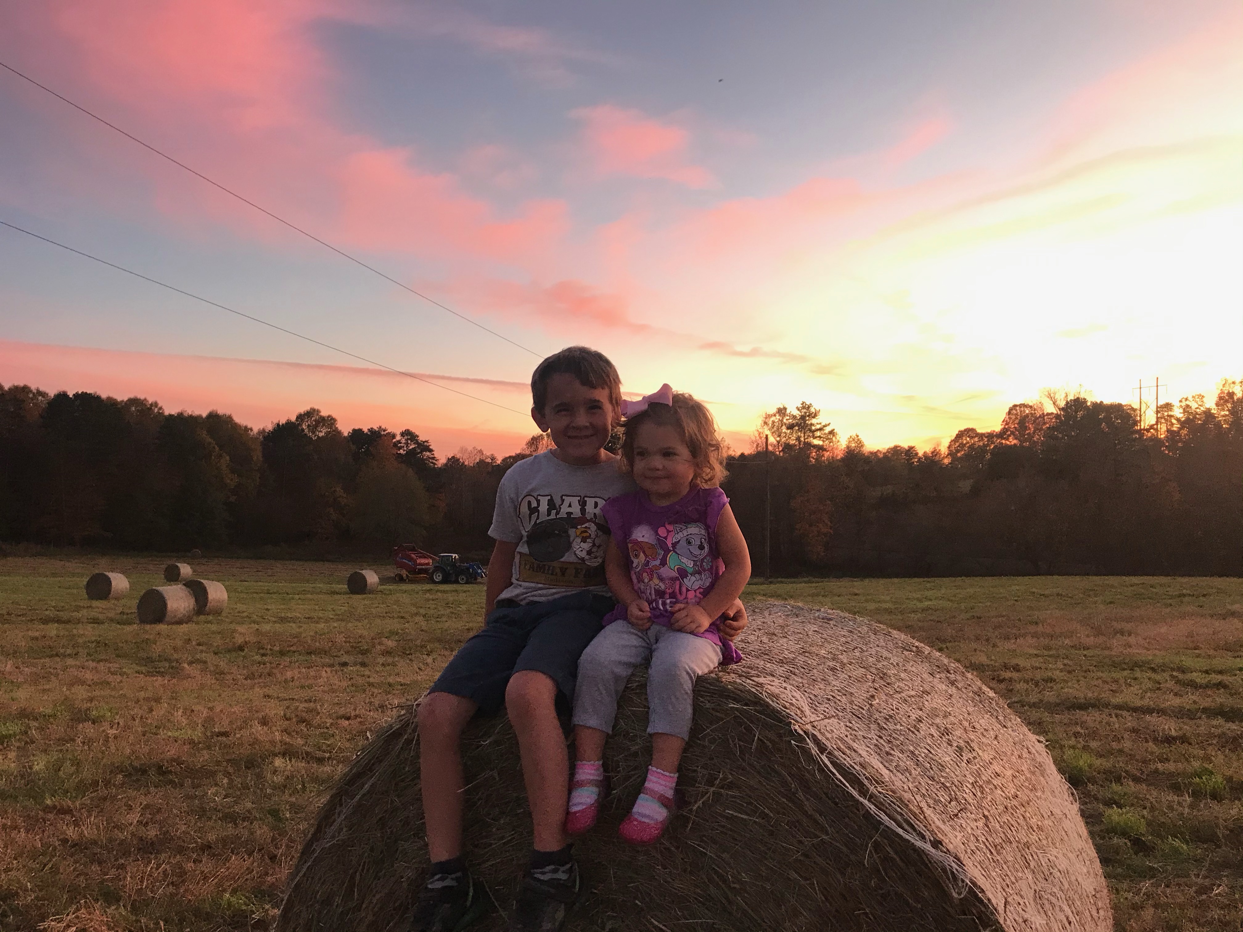 two kids on a hay bale