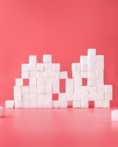 Sugar cubes stacked in front of pink background