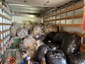 Several bags of wool in the back of a truck.
